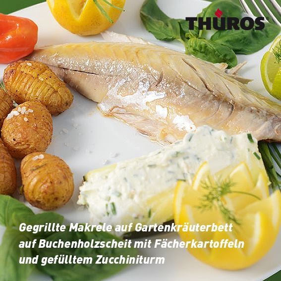 Gegrillte Makrele auf Gartenkräuterbett auf Buchenholzscheit mit Fächerkartoffeln und gefülltem Zucchiniturm